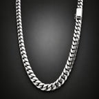 A silver-toned Cuban link chain necklace with a polished finish, arranged in a U-shape against a dark gray gradient background.