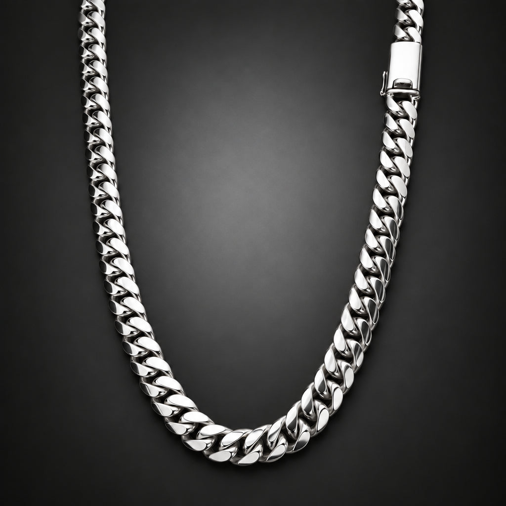A silver-toned Cuban link chain necklace with a polished finish, arranged in a U-shape against a dark gray gradient background.