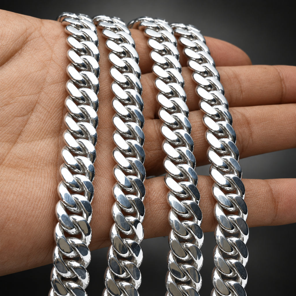Three silver chain bracelets on a person's wrist with a dark background