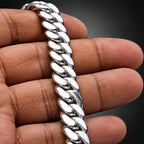 Silver chain bracelet on a person's wrist with a dark background