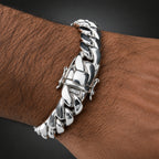 Silver chain bracelet on a person's wrist with a dark background