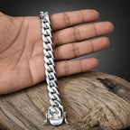 Silver chain bracelet on a hand with a wooden surface background