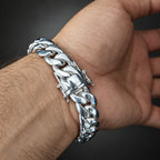 Silver chain bracelet on a wrist with a dark background