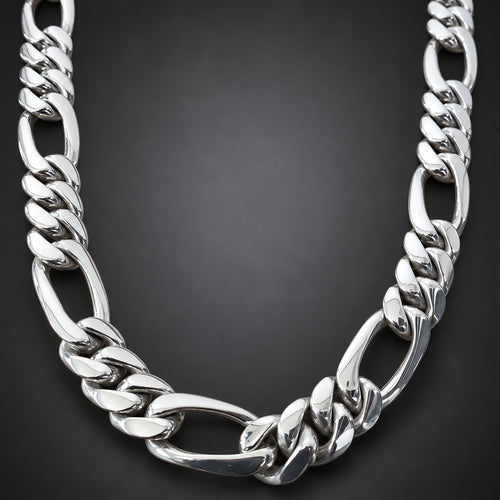 A polished silver-tone Cuban link chain necklace displayed on a light brown wooden surface.