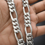 Close-up of two silver chain necklaces on a hand.