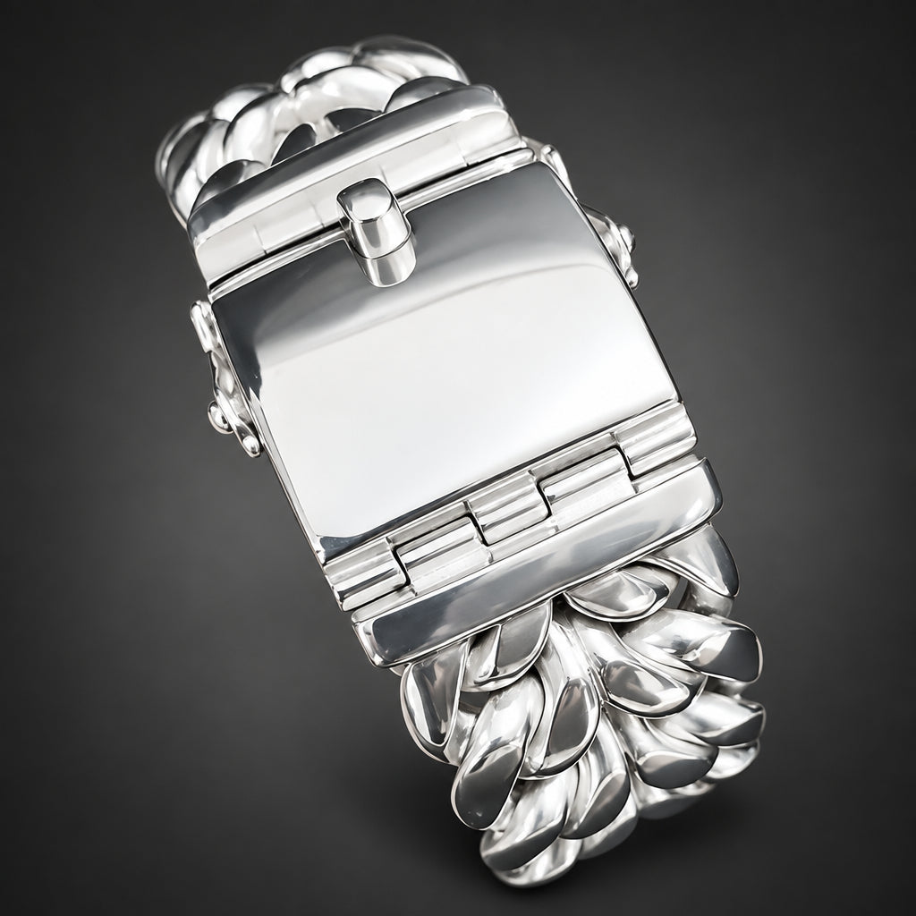 A close-up of a silver-toned metal watch band being held in a hand, showing the clasp and textured leaf-like links.