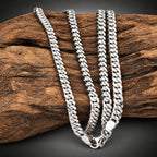 Silver chain necklace on a wooden log
