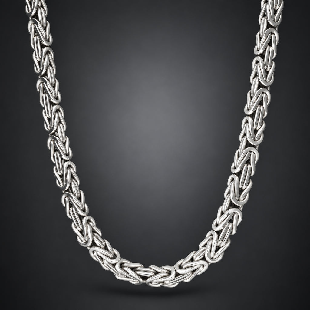 A silver-toned interlocking chain necklace with a braided or woven link design, shown draped against a dark gray gradient background.