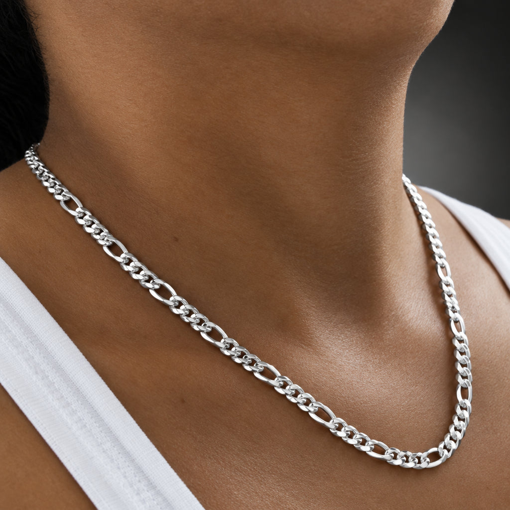Silver chain necklace worn by a person with a blurred background