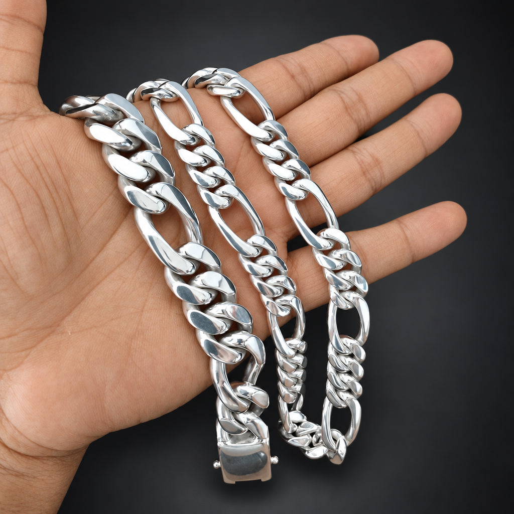 Three silver chain bracelets on a hand against a black background
