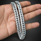 Silver braided bracelet on a hand against a dark background