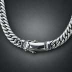 Silver chain bracelet on a dark background.