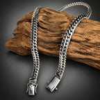 Silver chain necklace on a wooden block with a dark background