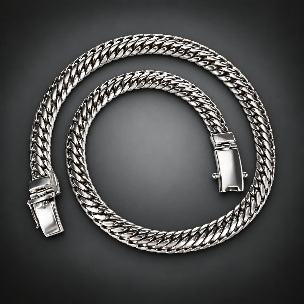 A thick silver-toned Cuban link chain necklace coiled on a dark gray gradient background.