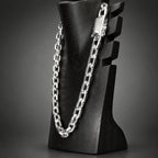 Silver chain necklace on a black mannequin bust against a white background