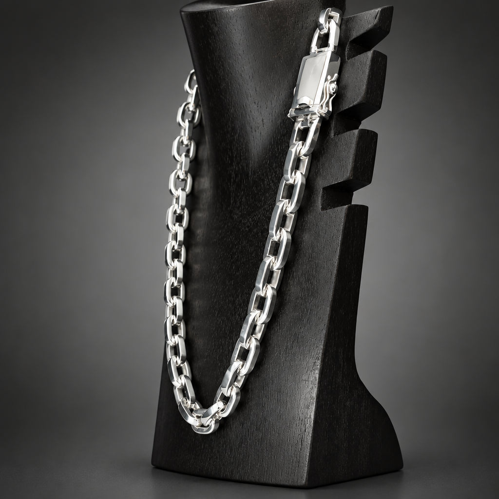 Silver chain necklace on a black mannequin bust against a white background