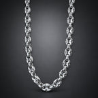 A polished silver-toned metal chain necklace with interlocking oval links, shown draped against a dark gray gradient background.