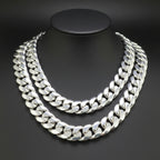 A thick silver Cuban link chain necklace displayed on a black mannequin bust against a dark gray background.