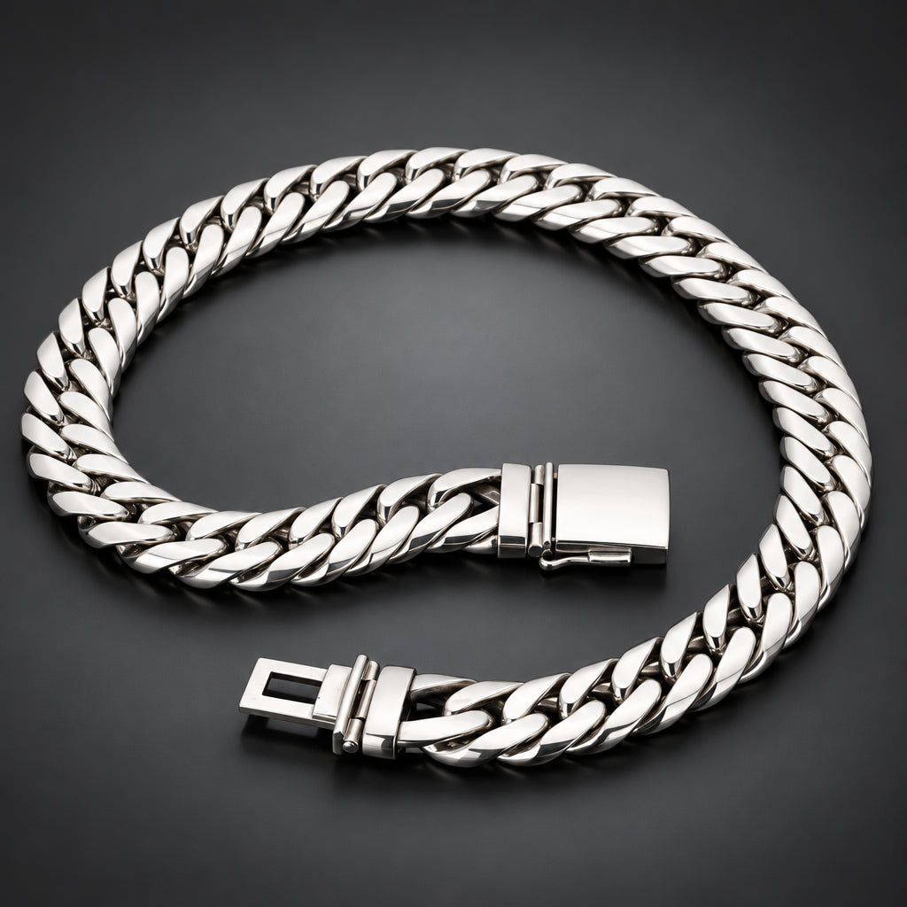 A silver-toned Cuban link chain bracelet with a polished rectangular clasp, displayed on a dark reflective surface.