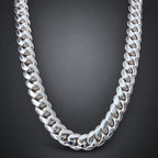 A chunky silver Cuban link chain necklace displayed on a light wood mannequin neck.