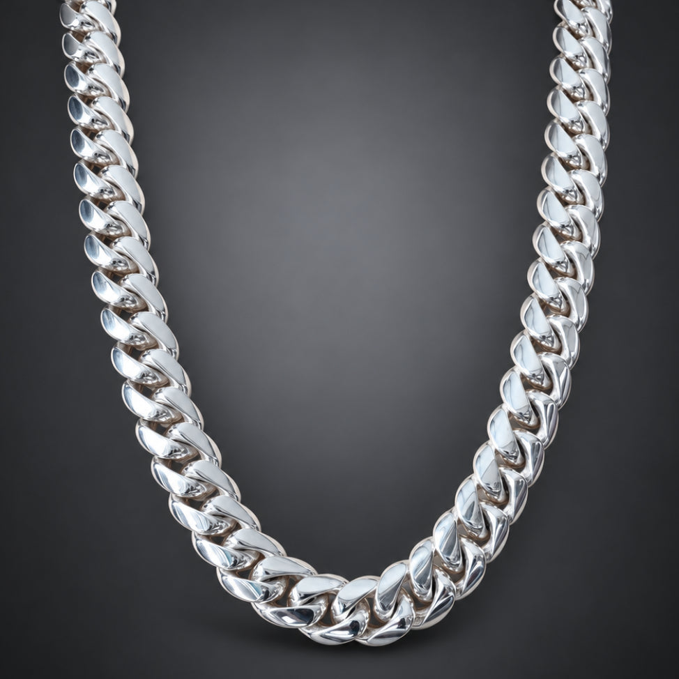 A chunky silver Cuban link chain necklace displayed on a light wood mannequin neck.