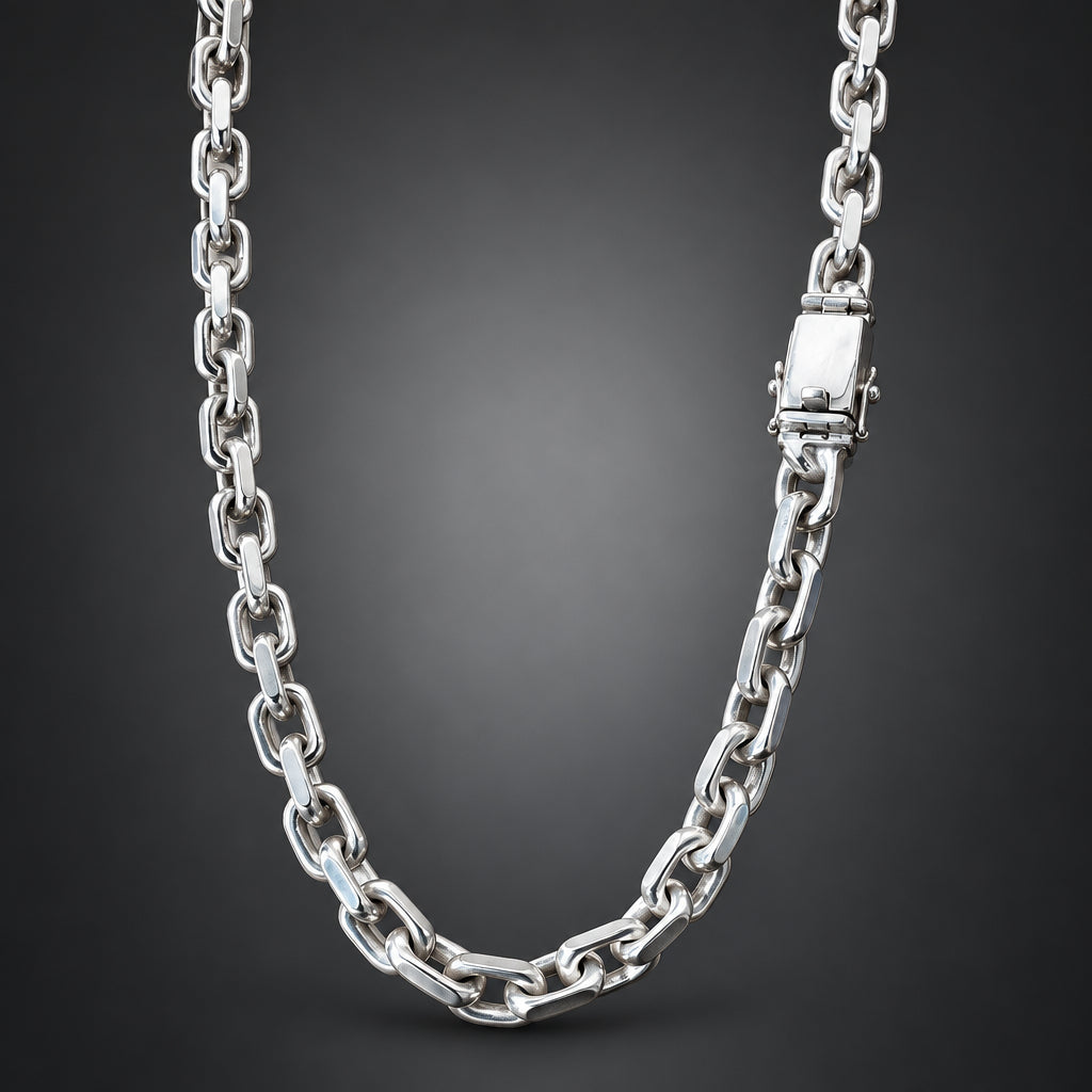 A polished silver-toned metal chain necklace with a rectangular clasp, shown draped against a dark gray gradient background.