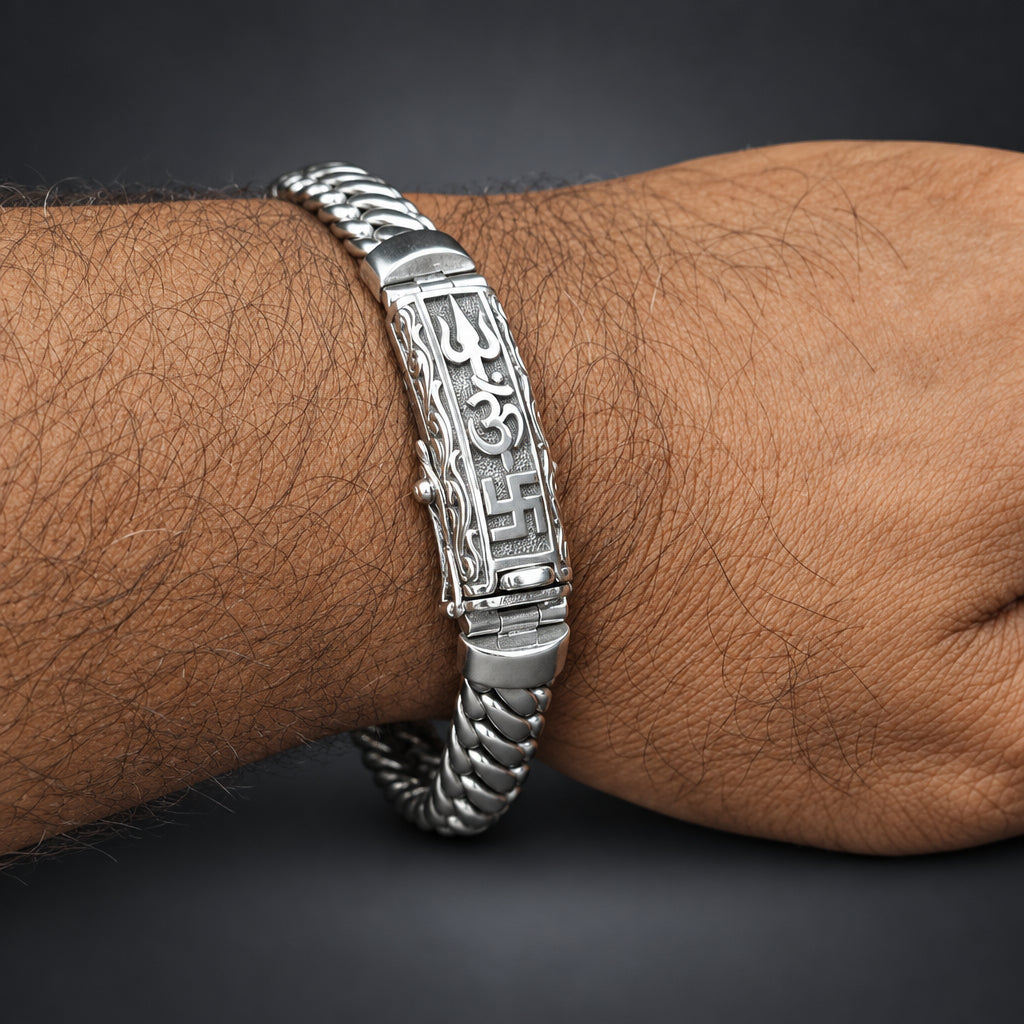Silver bracelet with intricate design on a wrist against a dark background