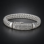 Silver bracelet with intricate design on a wooden surface