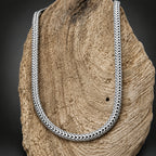 Silver braided necklace on a textured stone surface