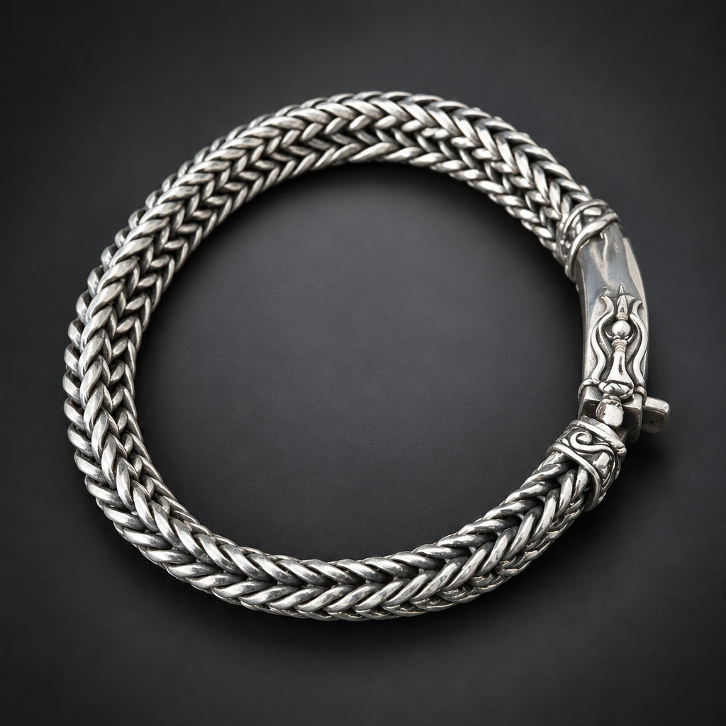 Silver braided bracelet on a hand against a dark background