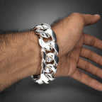 Silver chain bracelet on a wrist against a white background