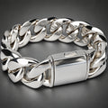 A polished silver-tone metal chain bracelet with a rectangular clasp, photographed close-up on a light neutral background.