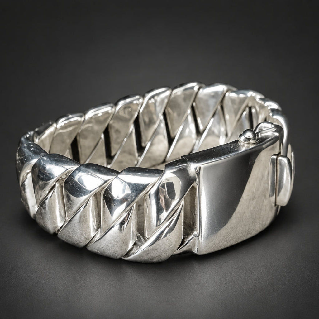 A polished silver-toned metal bracelet with a textured, geometric, diamond-patterned band and a sliding clasp, displayed on a dark gray background.