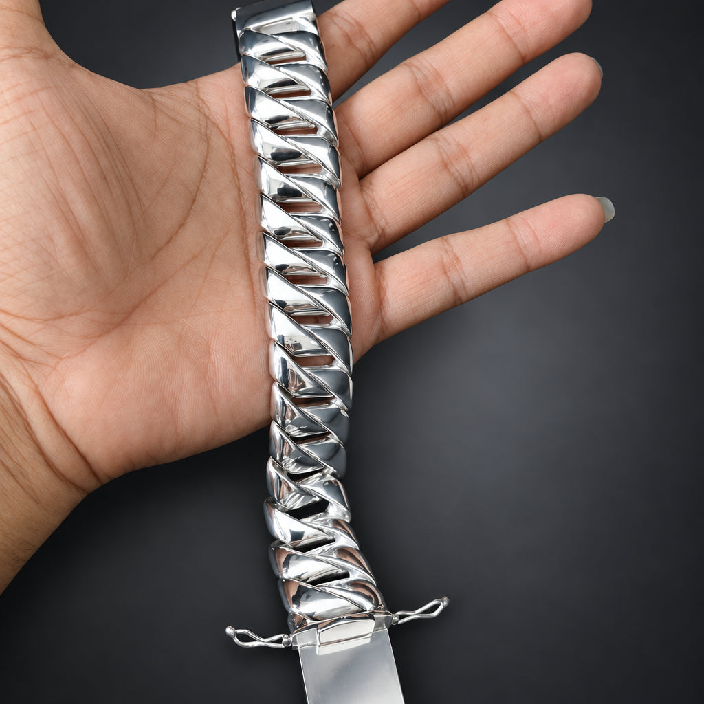 Silver chain bracelet on a hand against a dark background