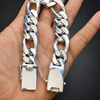 Silver chain with gold padlock held in a hand against a black background