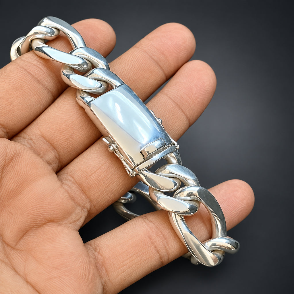 Silver chain bracelet on a person's wrist against a dark background