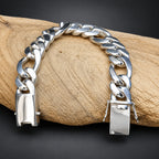 Silver chain bracelet with gold lock on a wooden surface