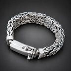 Silver braided bracelet on a hand with a dark background