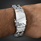 Silver bracelet on a wrist with a dark background