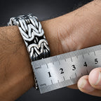 Silver bracelet on a wrist with a ruler for size reference