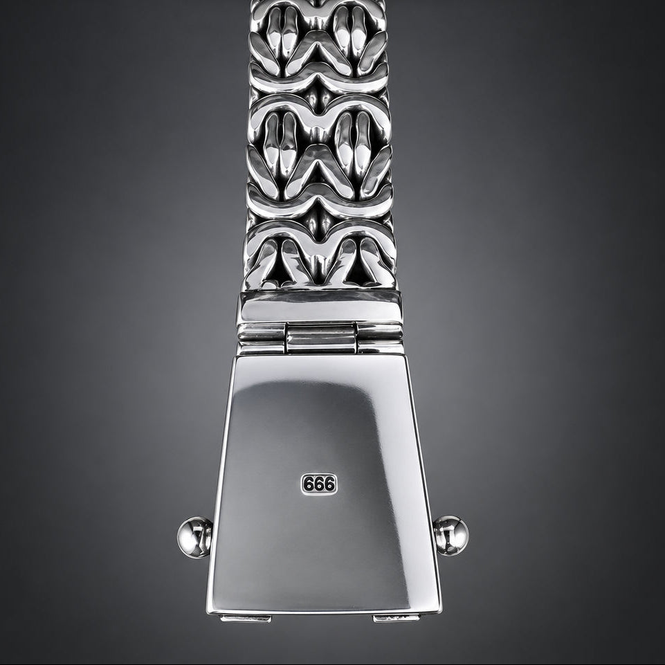 Silver watch with decorative band on a wooden surface