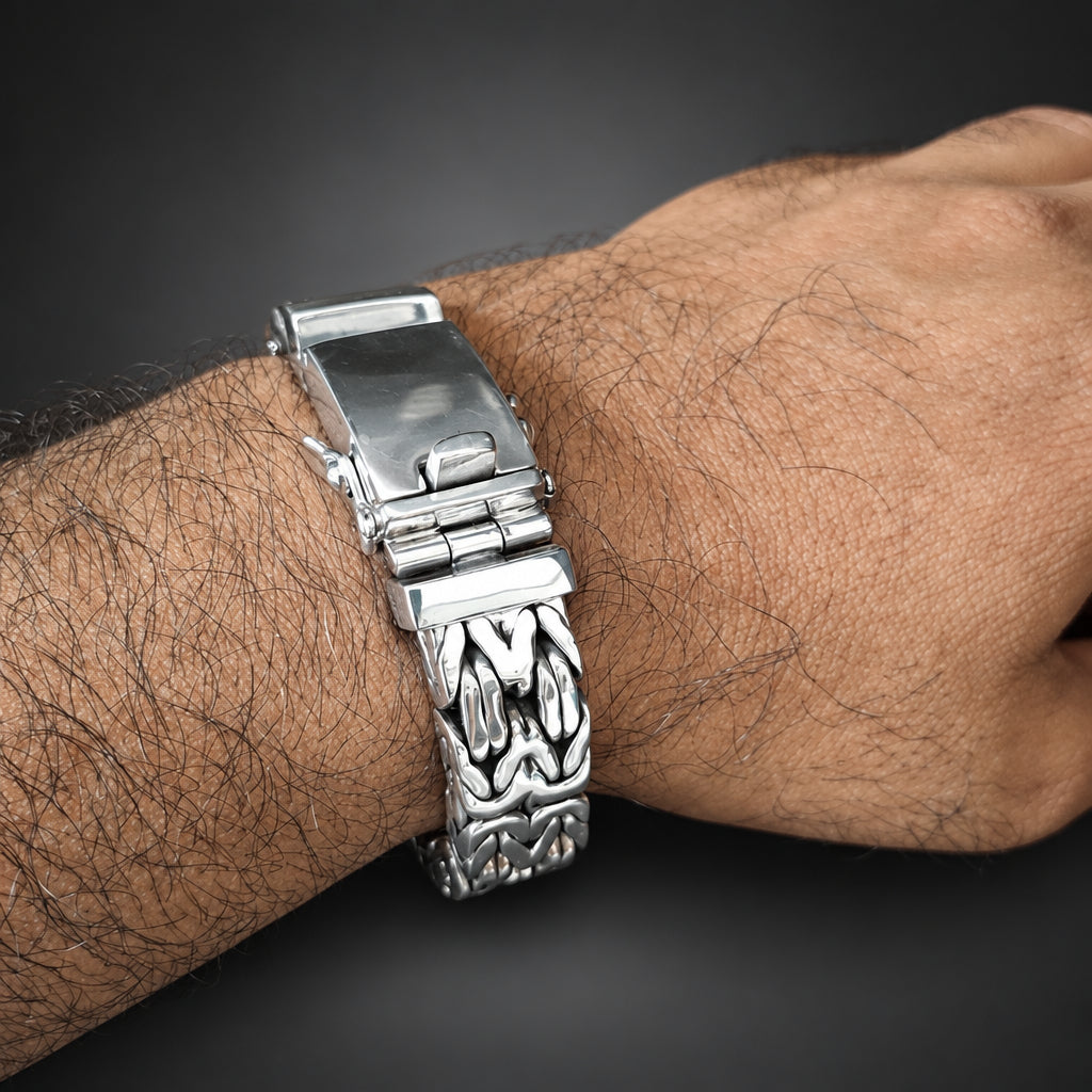 Silver bracelet on a wrist with a dark background