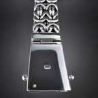 Silver metal watch band clasp and decorative link bracelet shown against a dark gray gradient background. The clasp features a polished rectangular back with a '999' sterling silver stamp, side screw posts, and a patterned link section below.