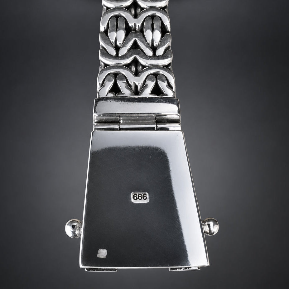 Silver metal watch band clasp and decorative link bracelet shown against a dark gray gradient background. The clasp features a polished rectangular back with a '999' sterling silver stamp, side screw posts, and a patterned link section below.