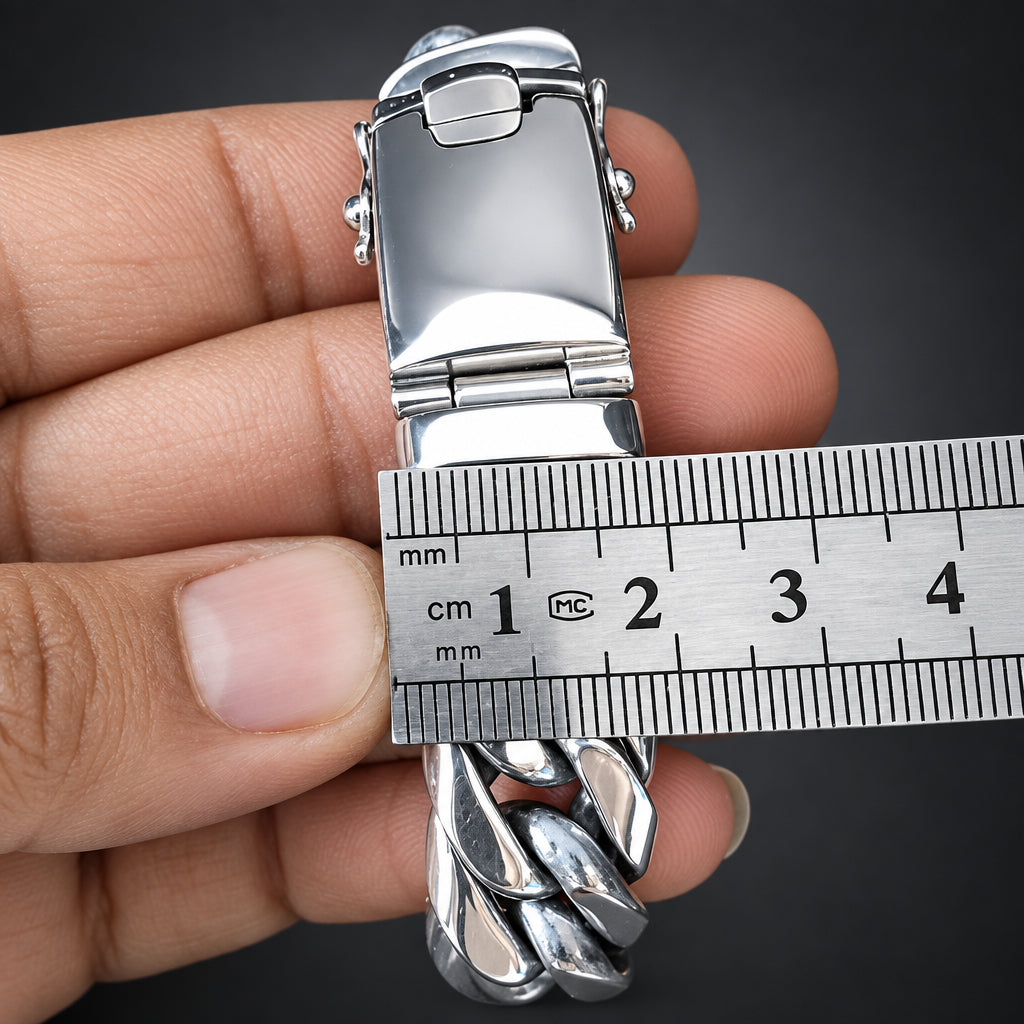 Silver bracelet being measured with a ruler against a person's wrist.
