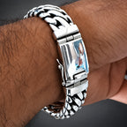 A close-up of a silver-toned metal link bracelet watch worn on a person's wrist.