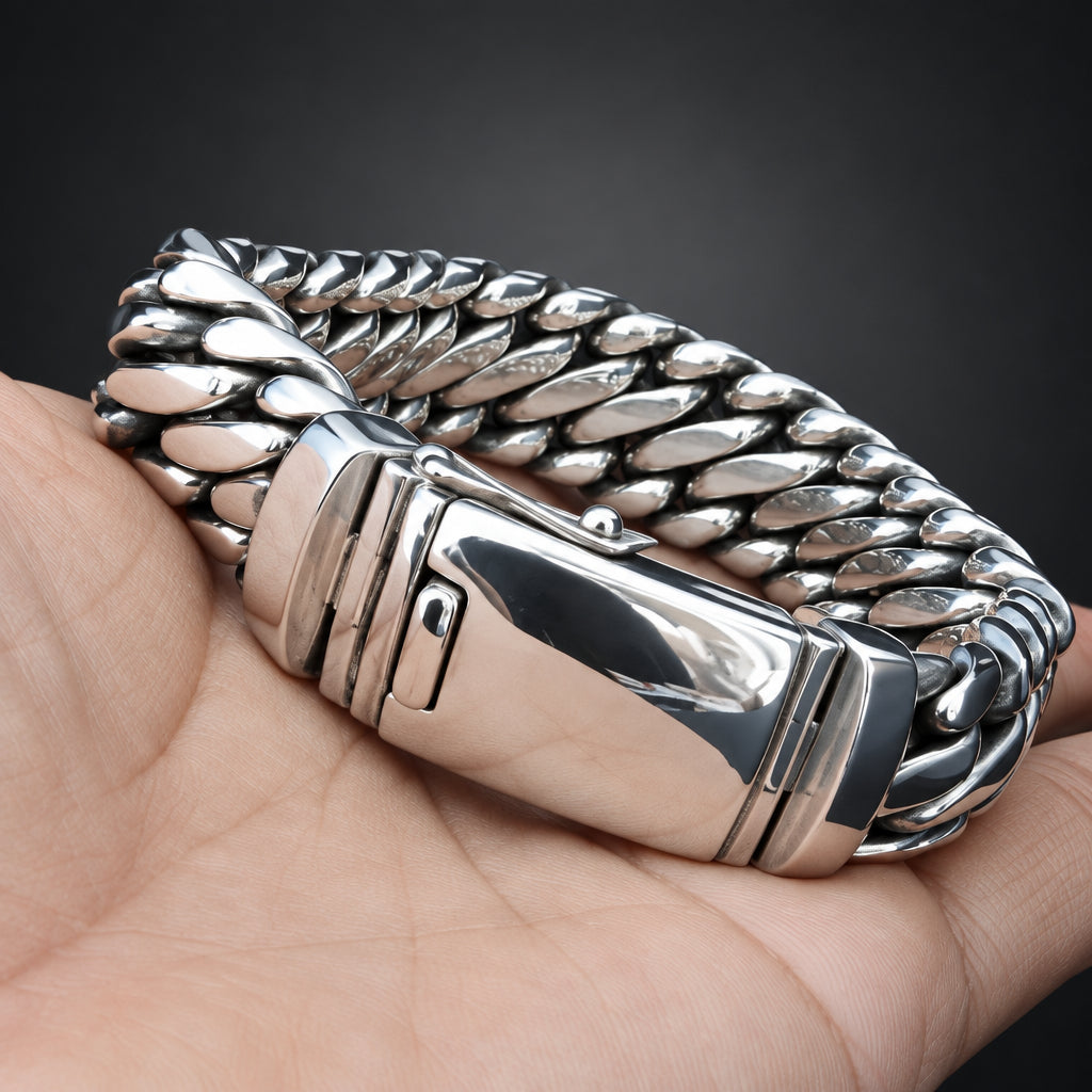 Silver chain-style ring on a hand against a black background