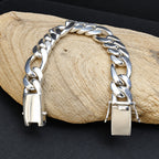 Silver chain bracelet on a wooden surface with a dark background