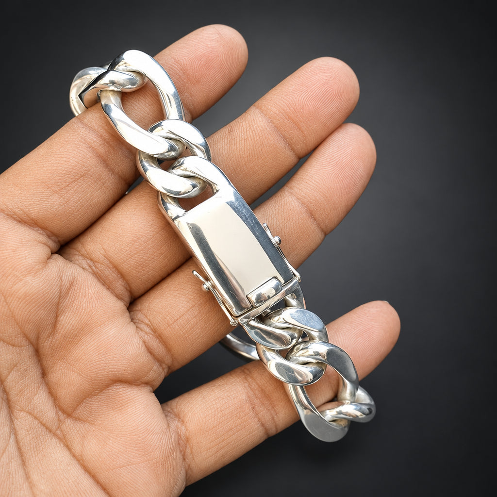 Silver chain bottle opener held in a hand against a dark background