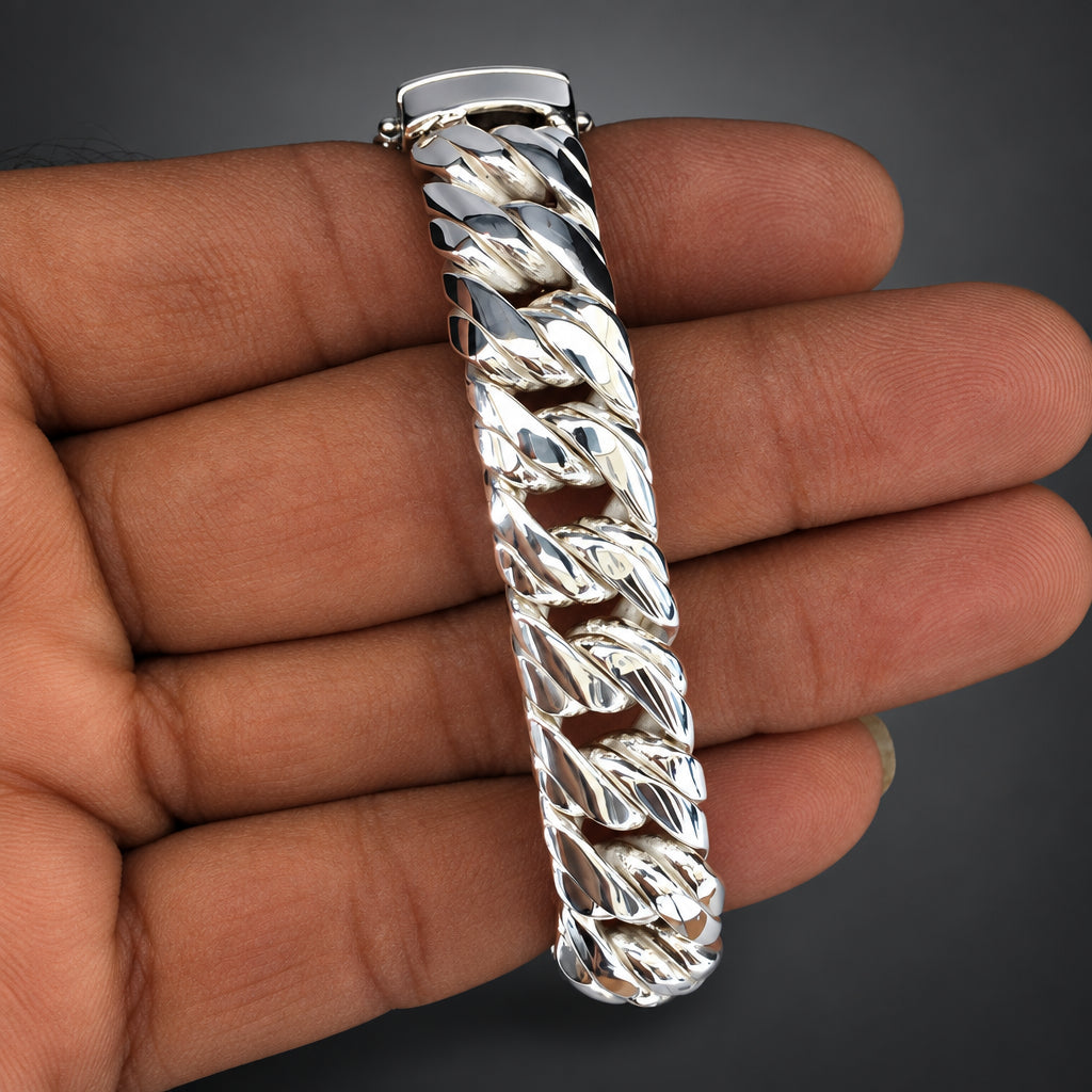 Silver braided bracelet held in a hand against a neutral background